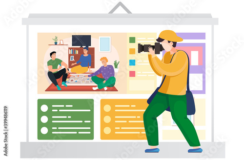 Guy takes pictures of poster with a picture. Friends sit on the floor and play a board game. People communicate and spend time together. Photographer during a billboard photo session in the apartment