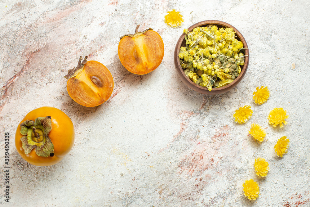 a bowl of bright yellow flower and palms on white marble background a bowl of bright yellow flower and palms on white marble background