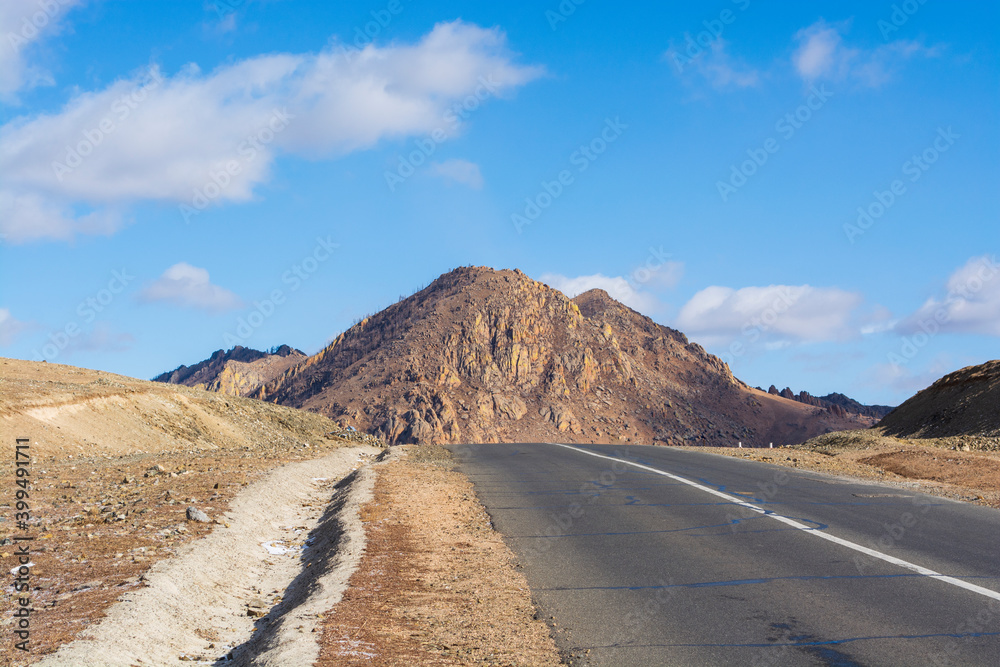 A beautiful mountain road without people and cars on a sunny day, a stunning landscape and an exciting way for car enthusiasts. The road on which you want to go forever, Mongolia A beautiful mountain road without people and cars on a sunny day, a stunning landscape and an exciting way for car enthusiasts. The road on which you want to go forever, Mongolia