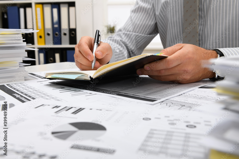 business concept - businessman working in office, table and workspace close view, checks financial reports, writes and counts business concept - businessman working in office, table and workspace close view, checks financial reports, writes and counts