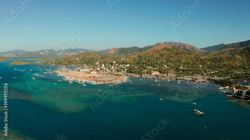 aerial view Coron City, tourist destination in the Philippines.Pier and promenade Coron town with boats on Busuanga island. Wooden boats waiting at pier. Seascape with mountains. Philippines, Palawan