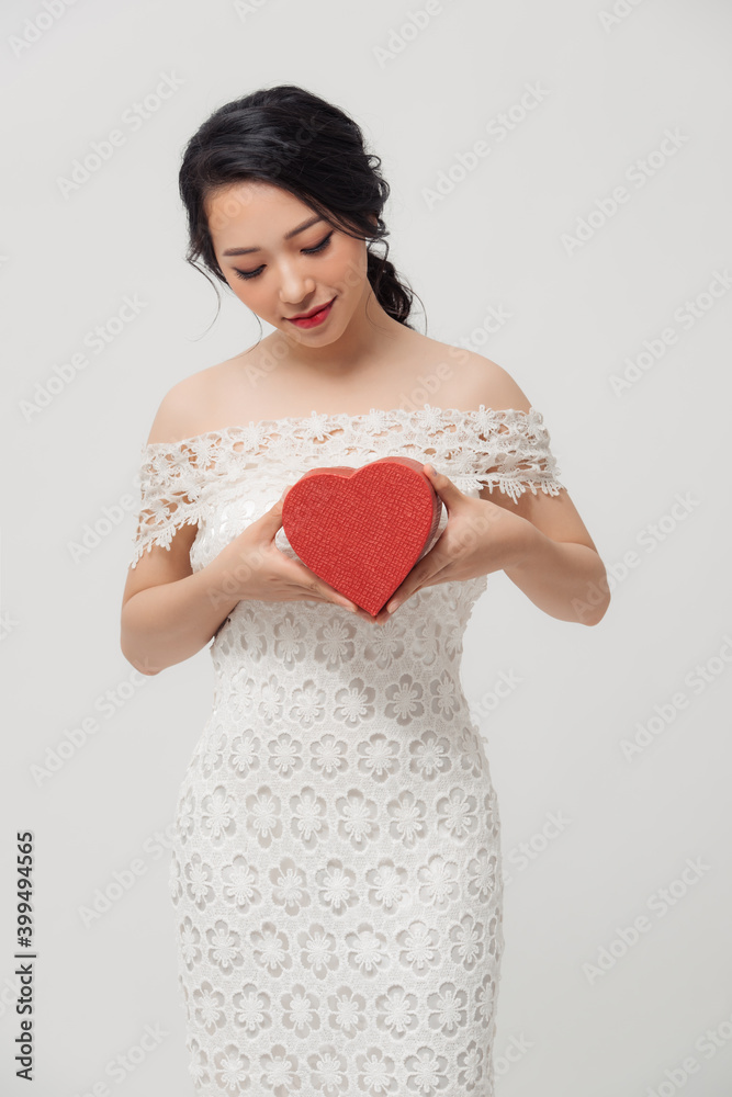 Beautiful young Asian woman holding love gift box isolated over white background. Beautiful young Asian woman holding love gift box isolated over white background.
