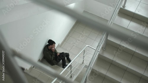 Male junkie taking drugs in the stairway photo