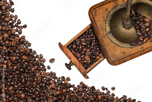 Old vintage manual coffee grinder with roasted coffee beans, isolated on white background. Top view.