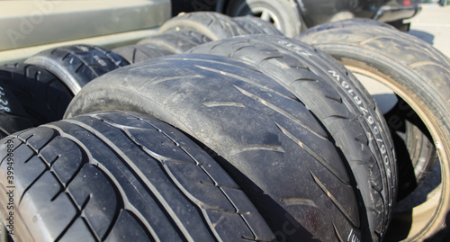 Worn out old bald and new car tires close up