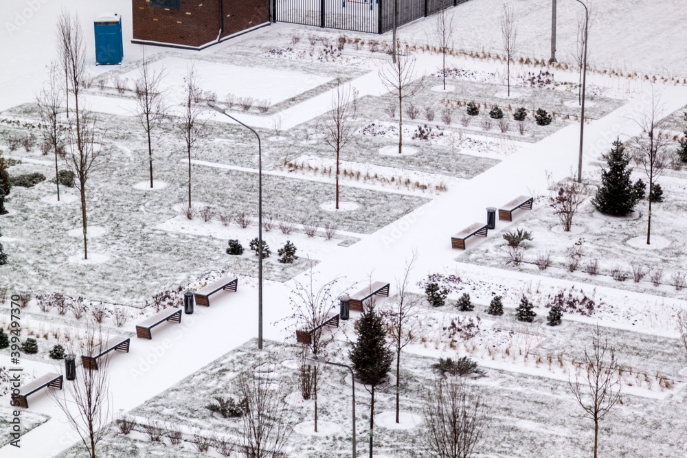 top view of winter public Park with benches, lanterns and snow-covered paths