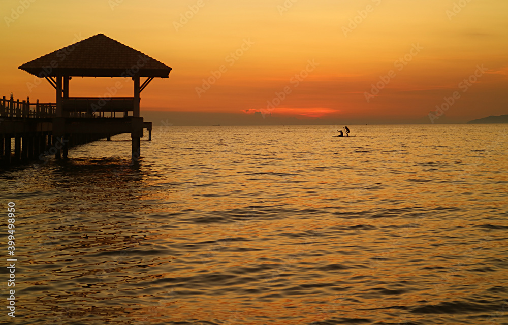 Silhouette of pair of stand up paddle boarders against beautiful sunset sky Silhouette of pair of stand up paddle boarders against beautiful sunset sky