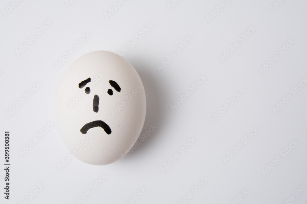 Egg with a sad and frustrated face, on a white background copy space. Egg with a sad and frustrated face, on a white background copy space.