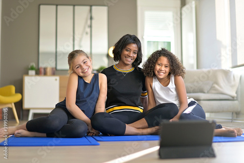 Woman with 2 young girls choosing virtual fitness class on internet