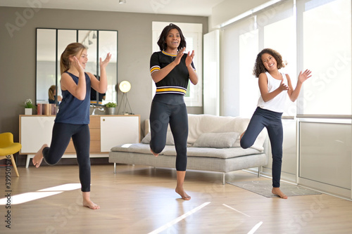Woman with girls doing fitness exercices at home