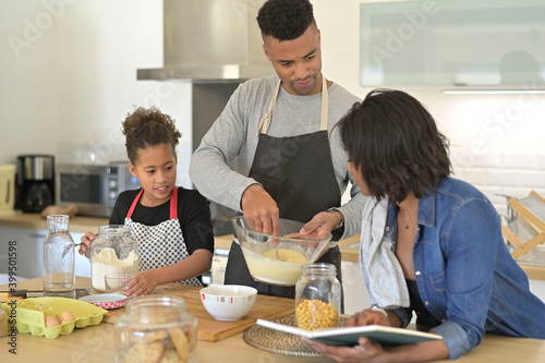 Happy family in home kitchen making homestyle american cookies