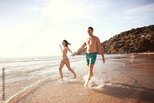lovers run along the beach / guy and girl run along the summer sea beach, rest on the sea honeymoon