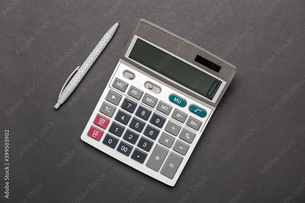 Modern calculator and pen on dark background Modern calculator and pen on dark background
