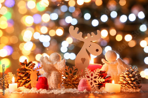 Christmas composition with decor and candles on table against blurred lights © Pixel-Shot