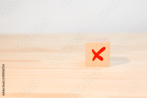 cross mark x on wooden cube. red cross sign on the edge of a wooden cube. Concept of negative decision making or choice of rejection.