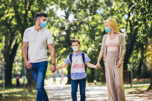 Mother,father and little son wearing face protective medical mask for protection from virus disease in park.