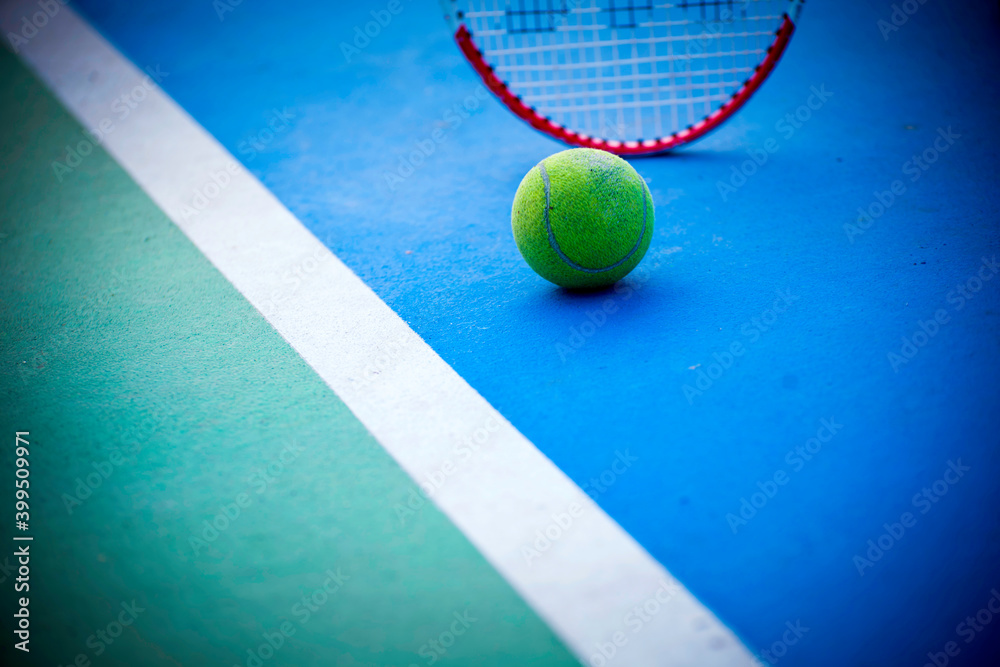 Tennis ball on tennis court with tennis racket. Tennis player waiting to play.