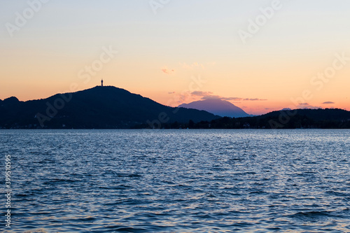 Alpine mountainous scenery on the great lake Klagenfurt am Worthersee, Carinthia region, Austria. Alps mountains. Summer holiday resort of many European tourists. 