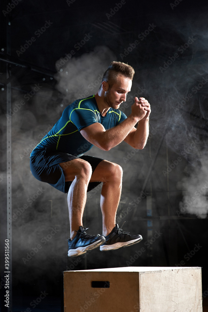 Box jump exercise young man doing functional workout at the gym Box jump exercise young man doing functional workout at the gym