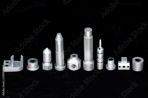 Shiny steel parts on a black background. Regular industrial metal production pattern.