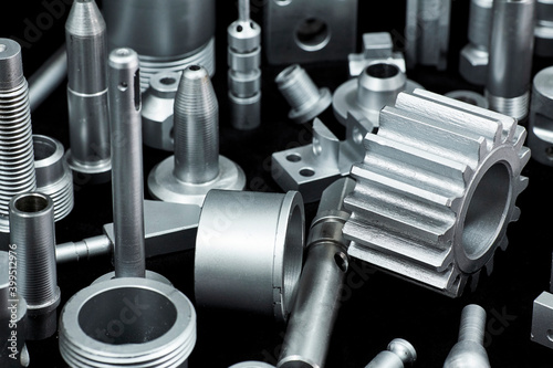 Shiny steel parts on a black background. Regular industrial metal production pattern.