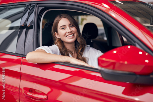 Happy young woman sitting in new car
