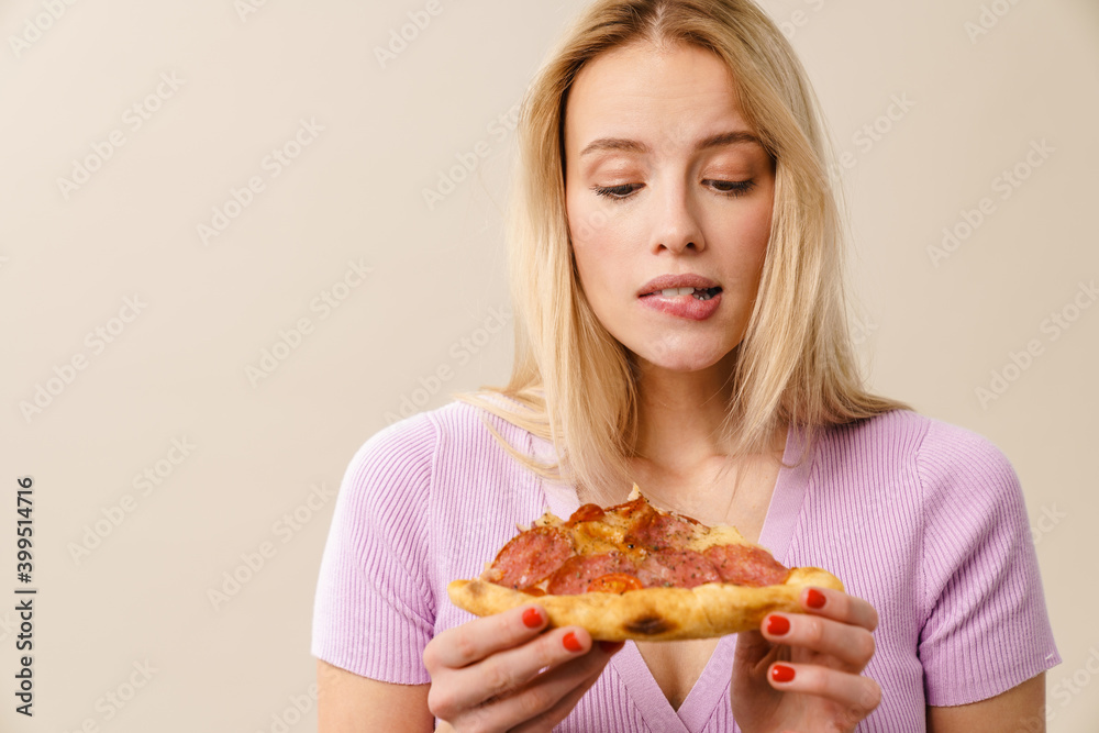 Confused beautiful blonde girl posing with pizza
