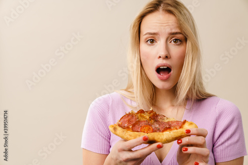 Shocked beautiful blonde girl exclaiming while posing with pizza