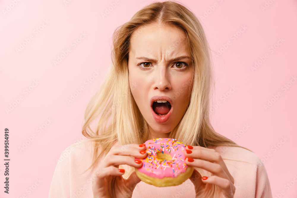 Shocked charming blonde girl posing with doughnut