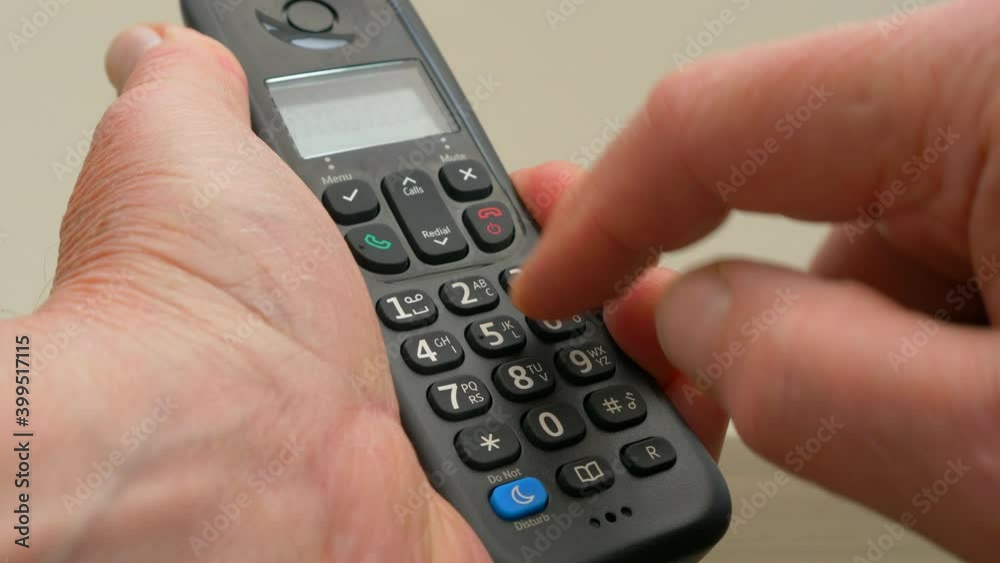 Closeup POV shot of a man’s hand pressing a series of telephone number buttons on a modern hands free, cordless landline handset, to make a phone call. Closeup POV shot of a man’s hand pressing a series of telephone number buttons on a modern hands free, cordless landline handset, to make a phone call.