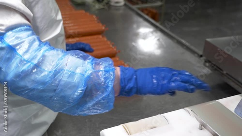 At the meat processing plant, sausage is collected from the conveyor