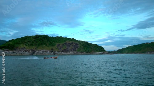 Small boat with passenger sailing accross the sea near the island