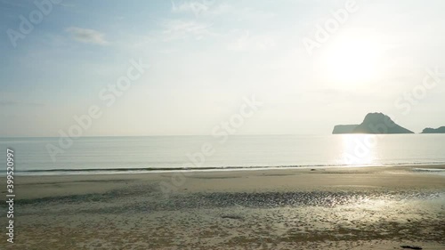 Walking pass a light pole along the beach sun rise on a mountain