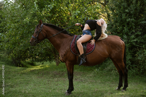 Beautiful woman stands with a horse in nature on the background of the forest
