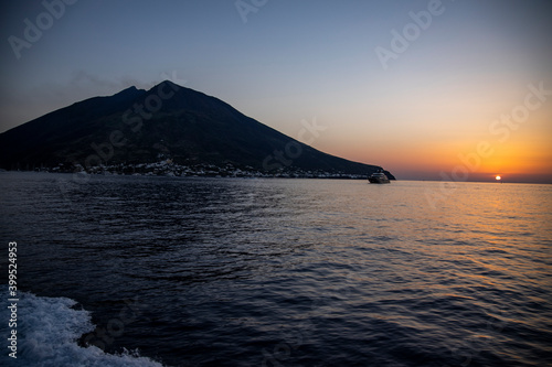 Lighthouse overlooking the sea  on an old inactive volcano  called Strombolicchio. The sunset creates a soft silhouette.