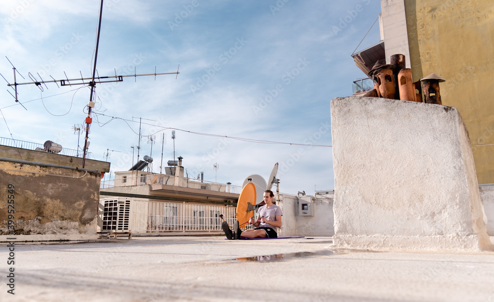 Man doing exercise on sport mat outdoors on home rooftop, covid-19 quarantine. Man doing exercise on sport mat outdoors on home rooftop, covid-19 quarantine.