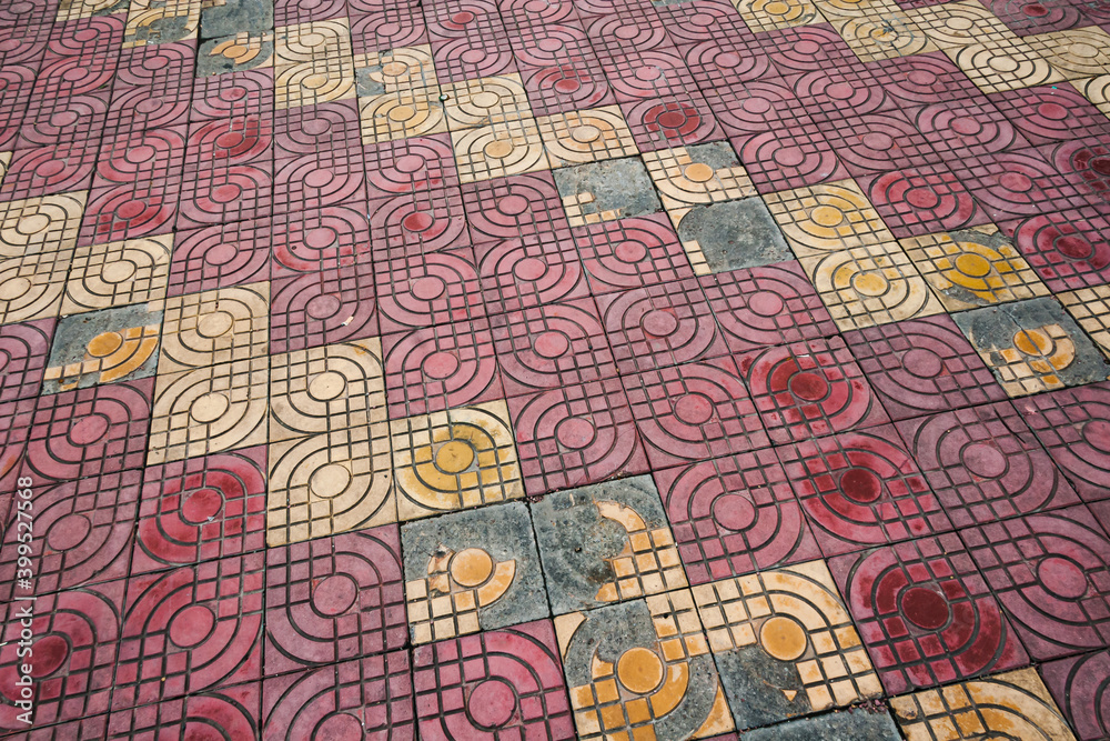 Old worn patterned ceramic kiln fired tiles in a public area. Shanghai, China.