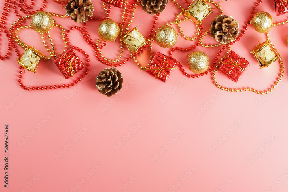 Christmas composition of decorations and Christmas toys on a pink background.