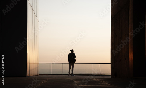Silhouette of person in frame of modern building during sunset. photo