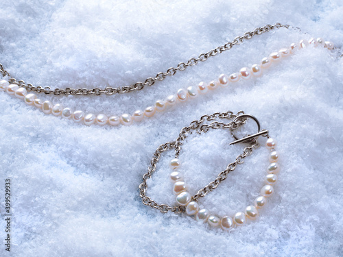 Luxury elegant baroque pearl bracelet and necklace on white snow background