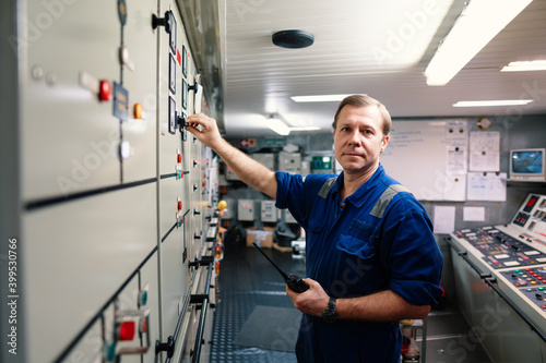 Photography Marine engineer officer controlling vessel engines and propulsion in engine control room ECR