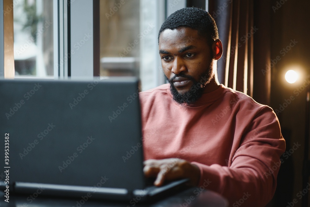 African american man working on laptop in a cafe African american man working on laptop in a cafe