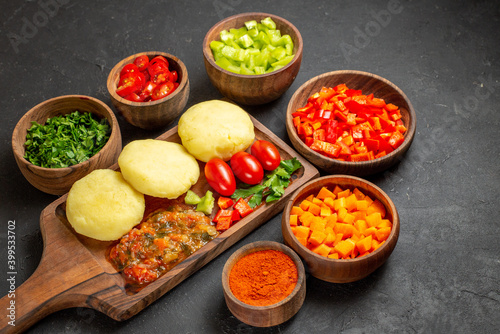 Horizontal view of cooking with fresh vegetables and chopped foods on the black table