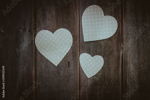white hearts on a dark wooden background, top view