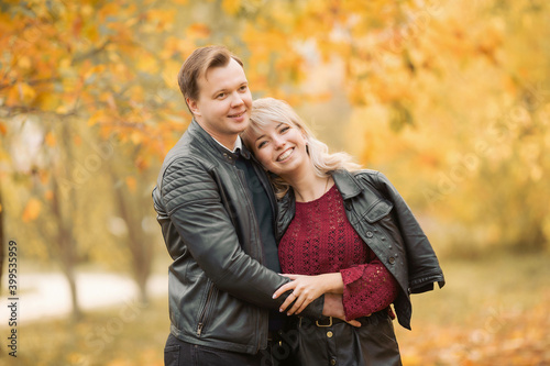 Young lovers hug and smile in the Park in autumn