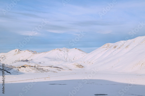  Plain of Castelluccio di Norcia and Monte Vettore. Landscape covered with white snow seen from drone. uncontaminated landscape  the silence of nature