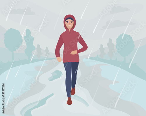 A woman running in the park in the rain and snow. Sports training on the street. Runner in motion. Marathon and long runs outside. running and fitness every day in all weathers. comfortable sportswear