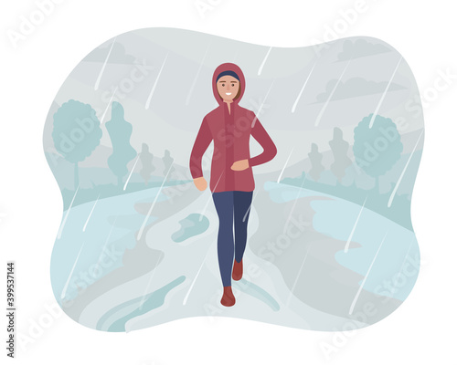A woman running in the park in the rain and snow. Sports training on the street. Runner in motion. Marathon and long runs outside. running and fitness every day in all weathers. comfortable sportswear