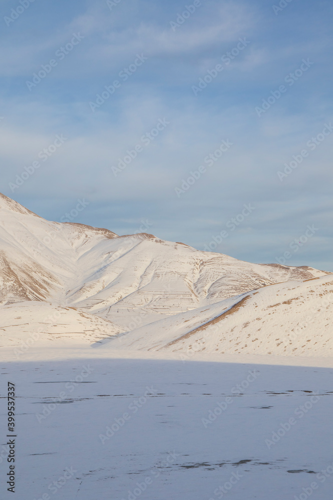 
Plain of Castelluccio di Norcia and Monte Vettore. Landscape covered with white snow seen from drone. uncontaminated landscape, the silence of nature