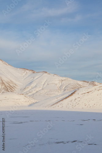  Plain of Castelluccio di Norcia and Monte Vettore. Landscape covered with white snow seen from drone. uncontaminated landscape, the silence of nature